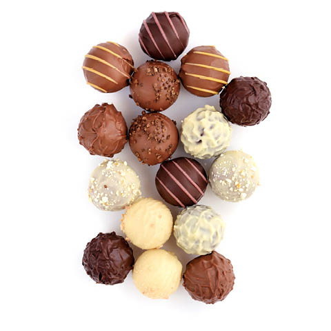 Chocolate pralines and filled bars produced using industrial chocolate processing equipment.